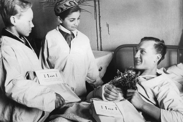 Боец Красной Армии Чичелимов, находящийся в госпитале после ранения, принимает первомайский подарок от пионеров 230-й школы, 1 мая 1943 года