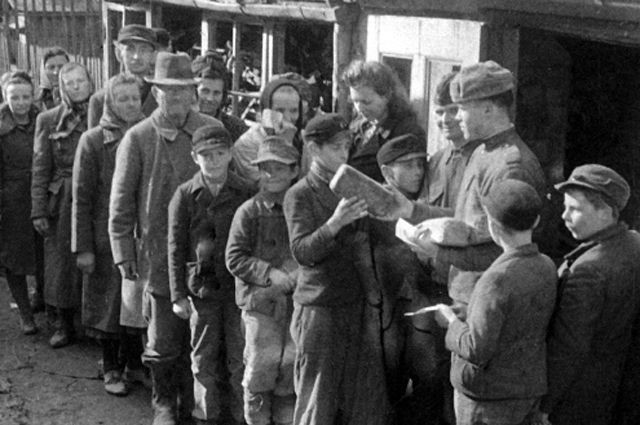 Советские воины раздают хлеб жителям города Бреслау в годы Великой Отечественной войны. / Фото: Эммануил Евзерихин / РИА Новости